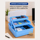 A blue three-tier plastic organizer tray with a clear lid, shown open on a wooden desk and filled with pens, sticky notes, chargers, and office supplies. Text at the top reads 'OFFICE & STATIONERY' and 'Keep your stationery, chargers, gadgets & office supplies tidy.