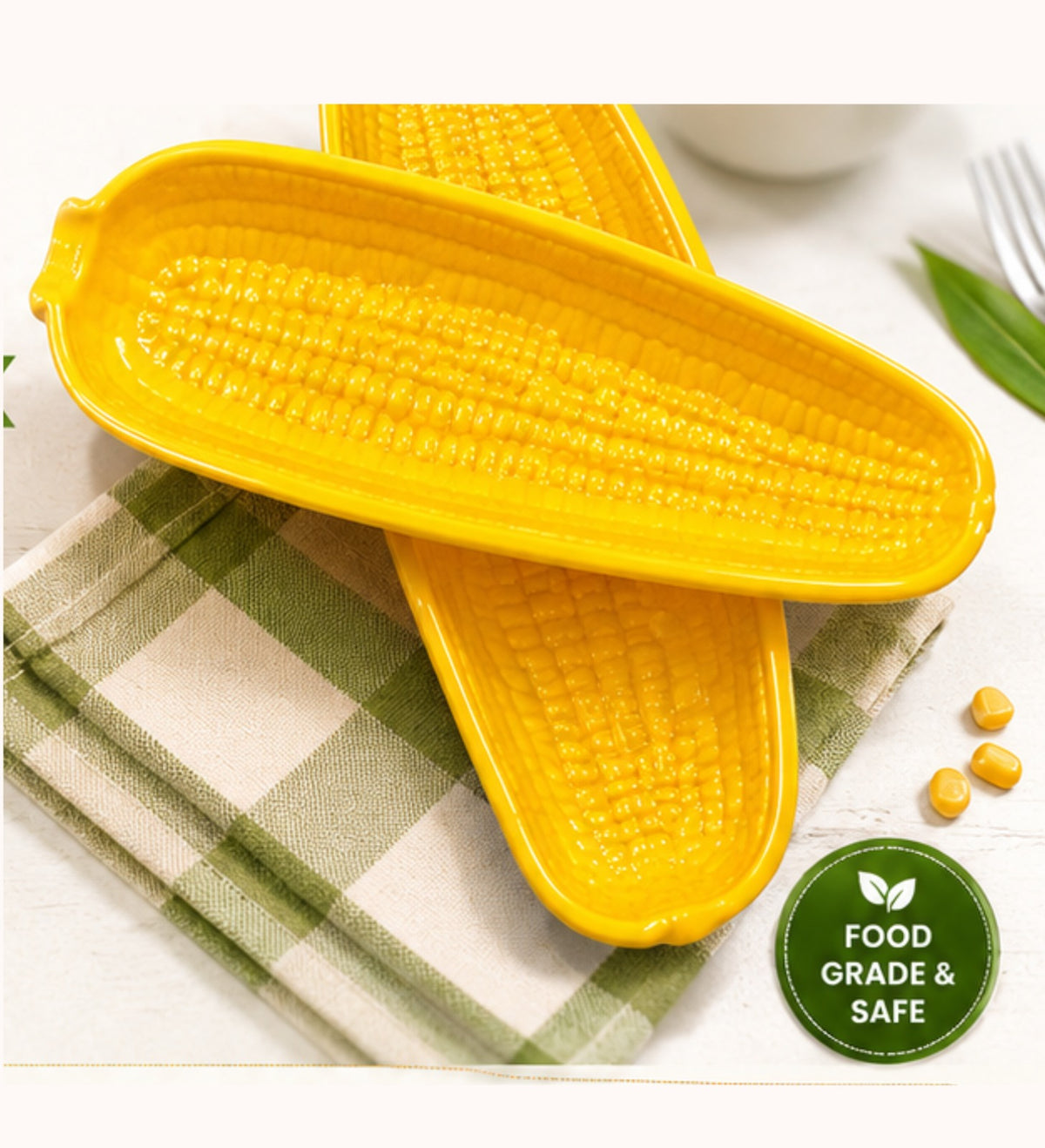 Yellow corn-shaped kitchen tool on a checkered cloth with a 'food grade & safe' label.