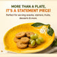 Yellow leaf-shaped plate with cookies and grapes on a beige background
