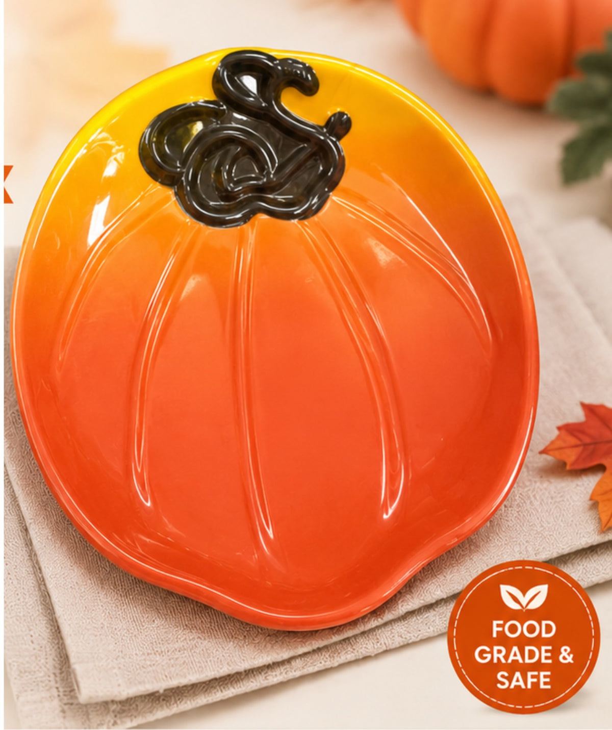 Pumpkin-shaped plate with a black stem on a beige surface, with a 'Food Grade & Safe' label.
