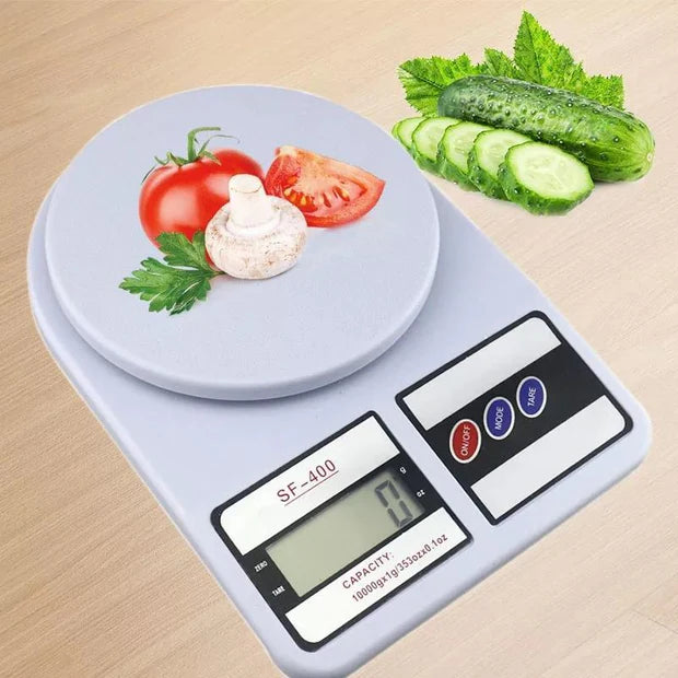 Digital kitchen scale with vegetables on a wooden surface