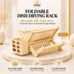 Omega Shop foldable wooden dish drying rack with a built-in plate organizer and cutlery holder, displayed on a marble pedestal with promotional text and feature icons.