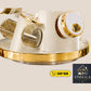 Decorative wall shelf with gold and white finish on a beige background, featuring 'Omega' brand logo.